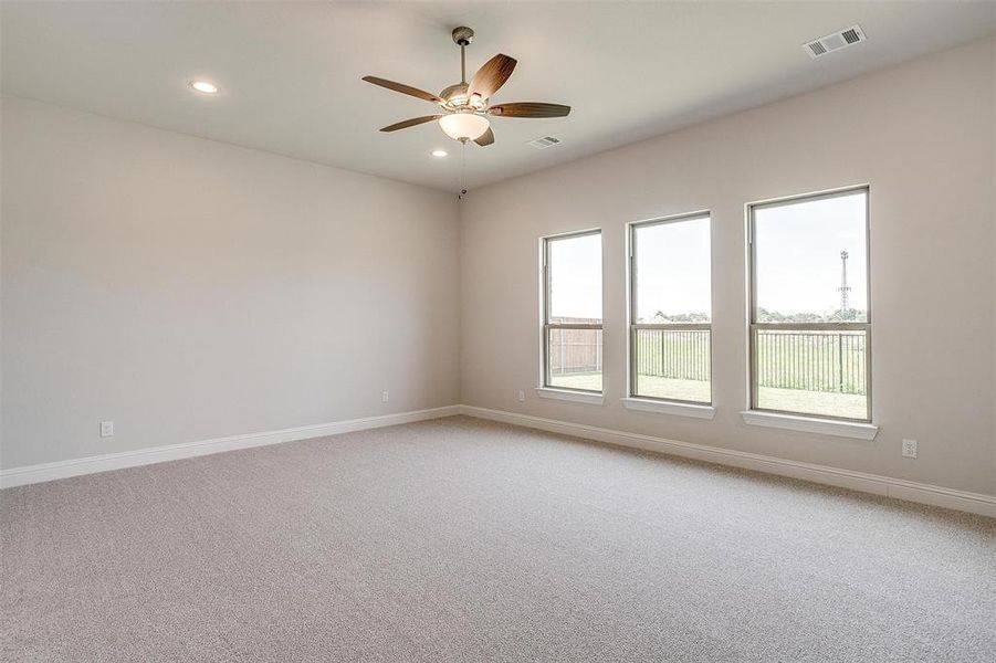 Carpeted empty room featuring ceiling fan