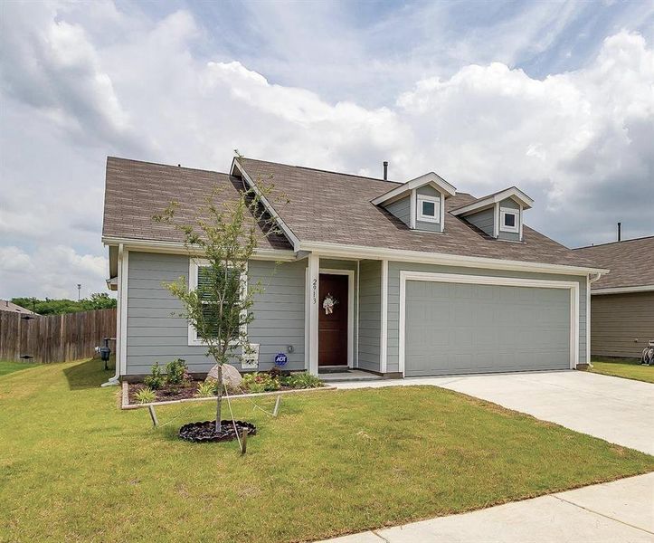 View of front of home with a front lawn and a garage