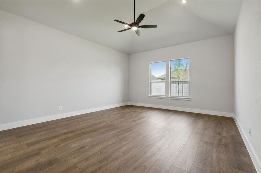 Spare room with ceiling fan, hardwood / wood-style floors, and vaulted ceiling