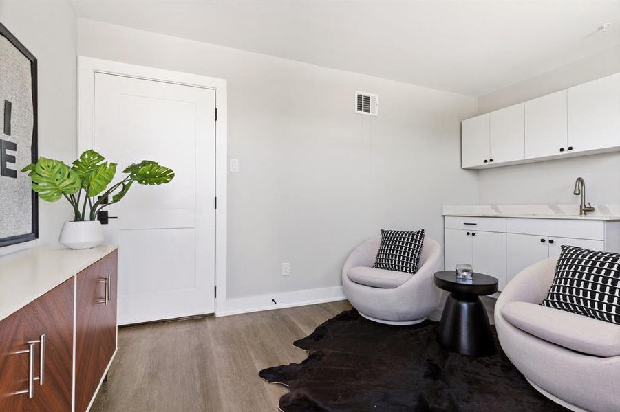 Living area with sink and hardwood / wood-style flooring