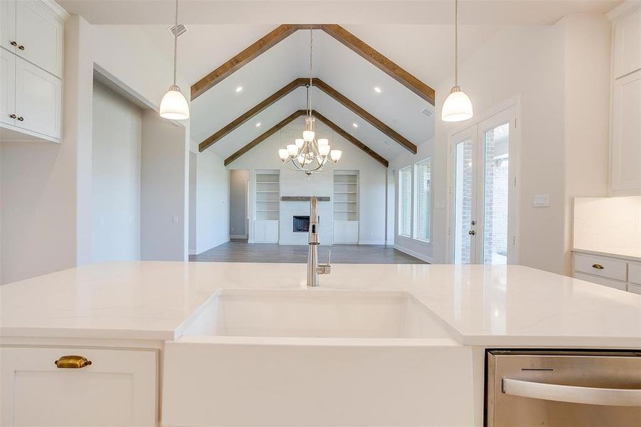 Kitchen with decorative light fixtures, white cabinetry, wood-type flooring, dishwasher, and beam ceiling