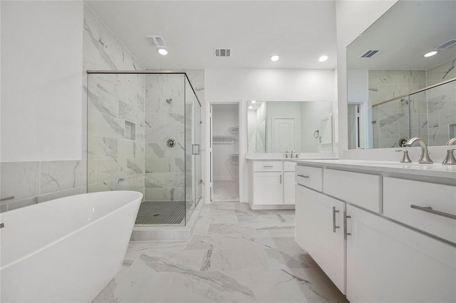 The Primary Bath is highlighted by the spacious shower and the separate soaking tub. Enjoy a nice bubble bath after a long day! (Sample photos of a completed Gibraltar floor plan. The image may feature alternative selections and/or upgrades.)