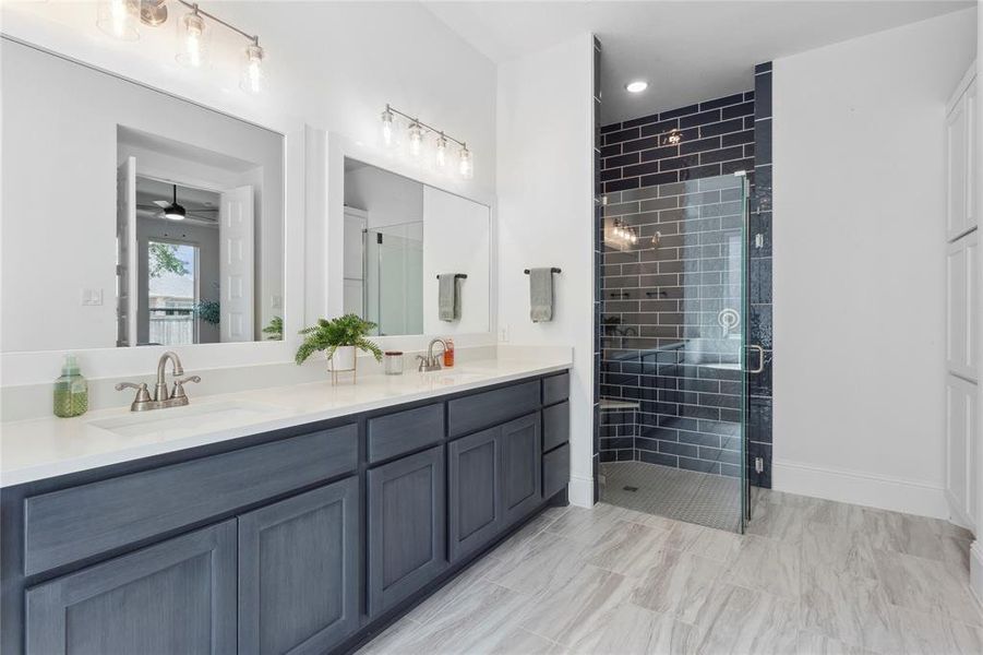 Double vanity with sapphire cabinets and oversized shower give an upscale feel to primary bath