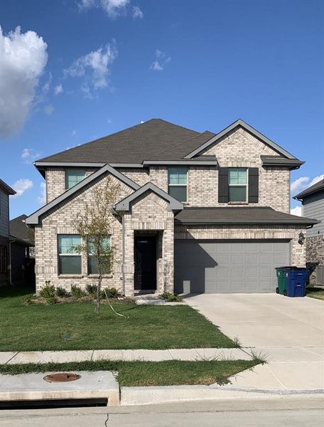 View of front of home with a garage and a front yard