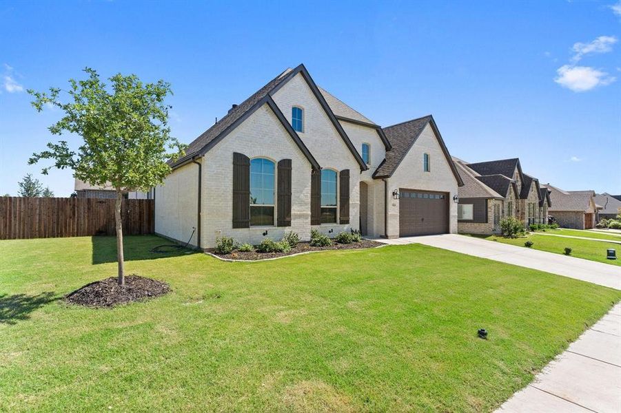 View of front of house with a garage and a front yard