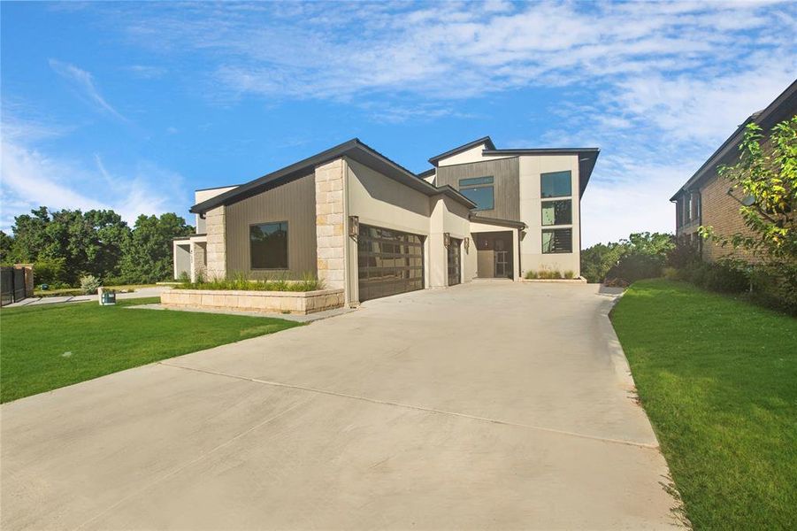 Modern home featuring a garage and a front lawn
