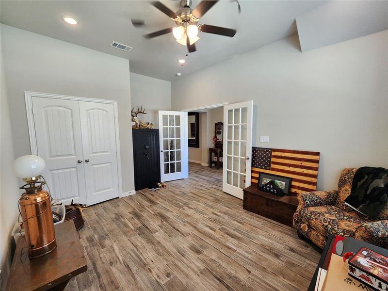 Living area with wood style flooring, ceiling fan, and french doors