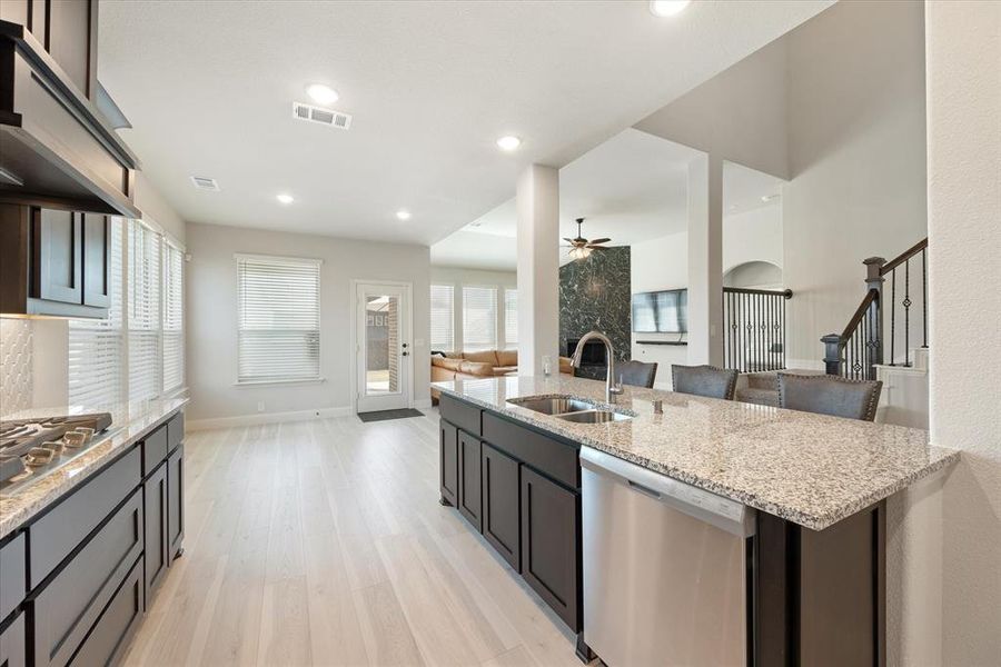 Kitchen includes engineered wood floors, undermount sink, and pots and pans drawers. Recessed canned lighting. Granite counters and breakfast bar. Breakfast room ahead is spacious but currently unfurnished.