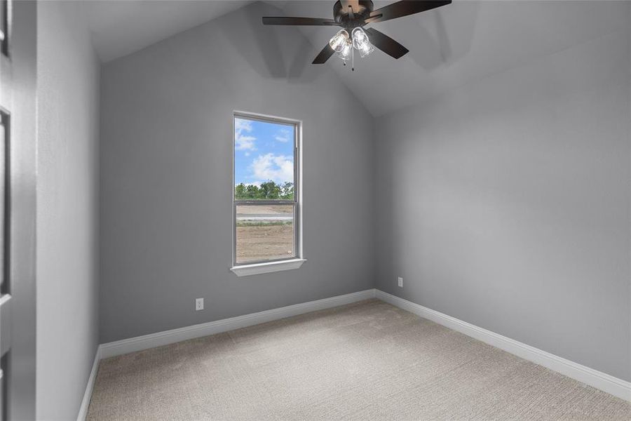 Unfurnished room with vaulted ceiling, light colored carpet, a wealth of natural light, and ceiling fan