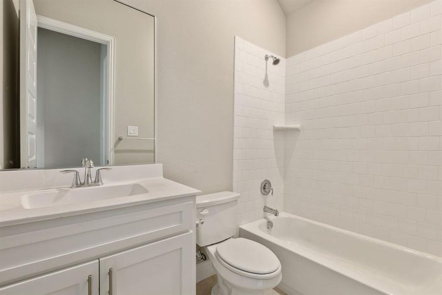 Full bathroom with vanity, toilet, and tiled shower / bath