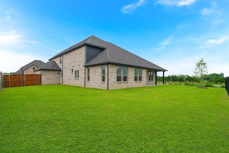 Rear view of house featuring a lawn