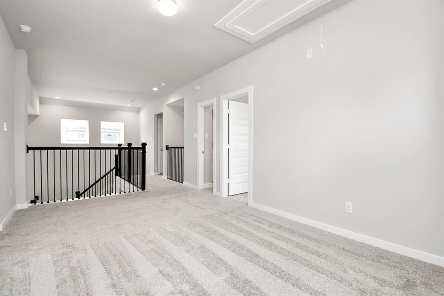 Come upstairs and enjoy a day of leisure in this fabulous game room! This is the perfect hangout spot or adult game room! Features plush carpet, high ceilings, custom paint and windows for plenty of natural light. Sample photo of completed home with similar floor plan. As-built interior colors and selections may vary.