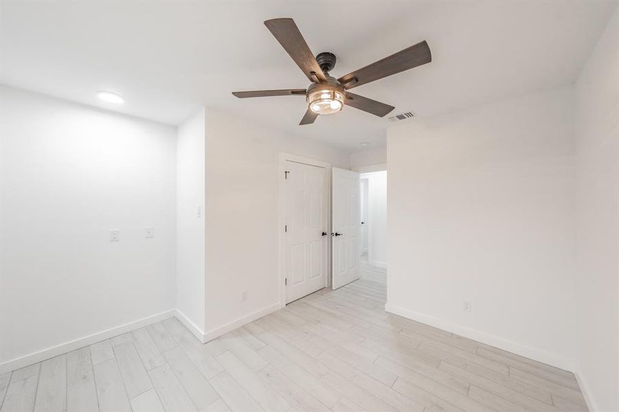 Empty room with light hardwood / wood-style floors and ceiling fan