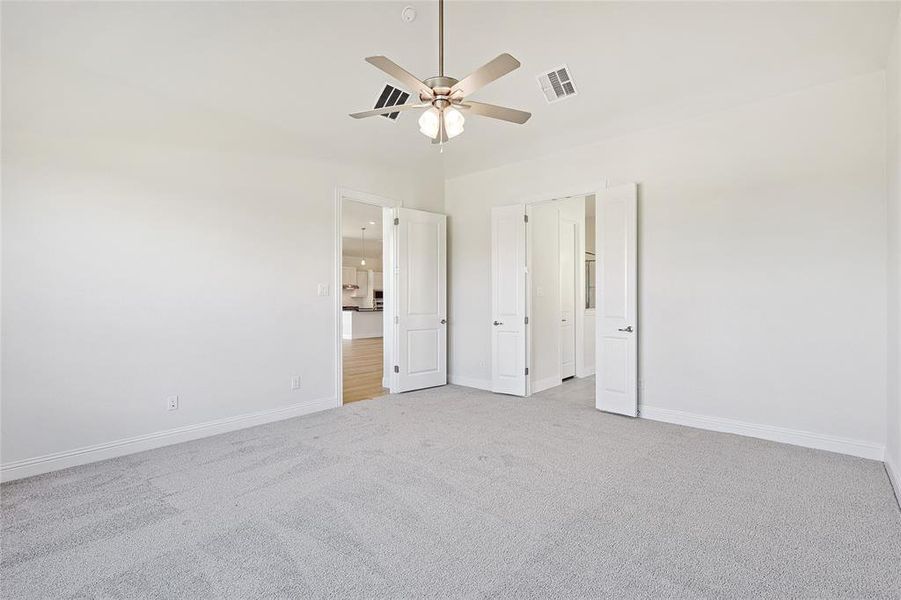 Unfurnished bedroom featuring ceiling fan and light colored carpet