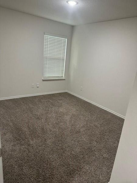 Unfurnished room with dark colored carpet