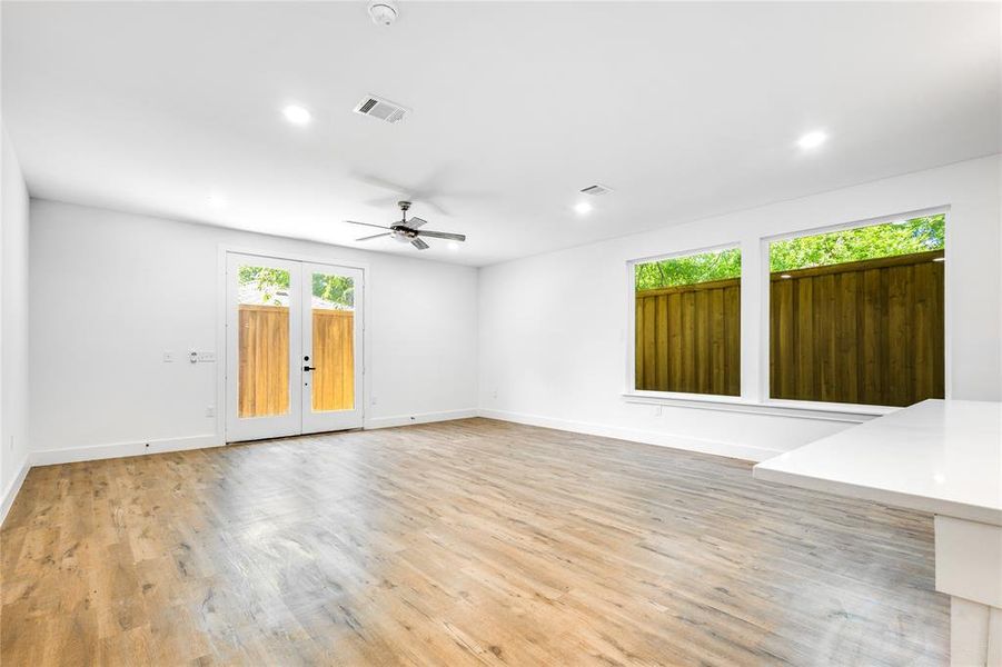 Unfurnished room featuring ceiling fan, plenty of natural light, french doors, and light wood-type flooring
