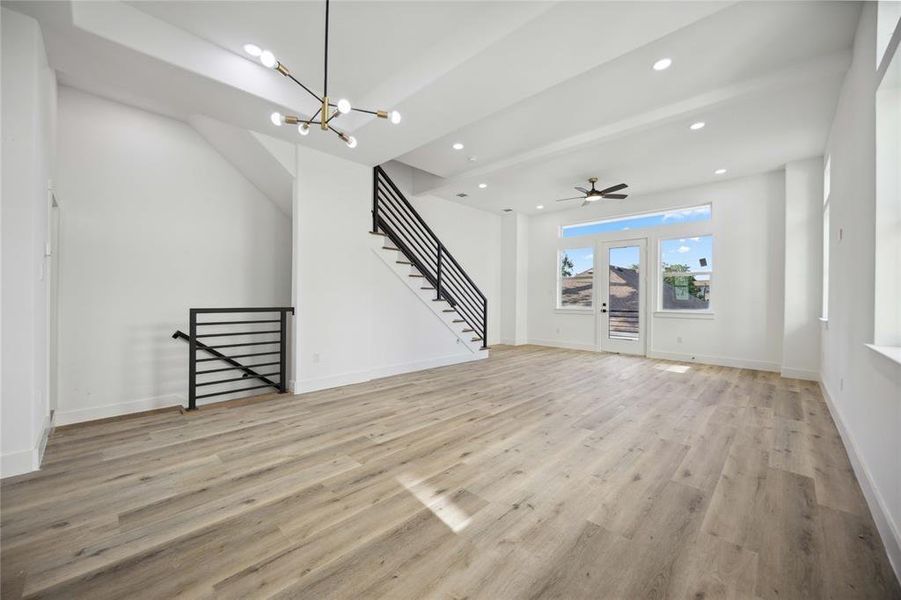 Experience an abundance of natural light in this spacious second floor living space featuring expansive windows, sleek modern lighting, and contemporary stair railing.