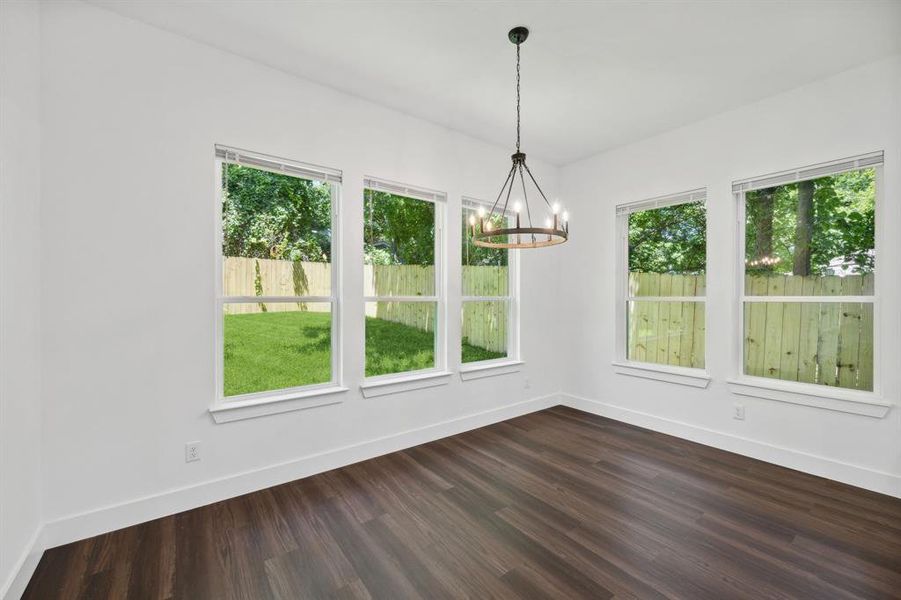 Unfurnished dining area featuring a chandelier and dark wood-type flooring