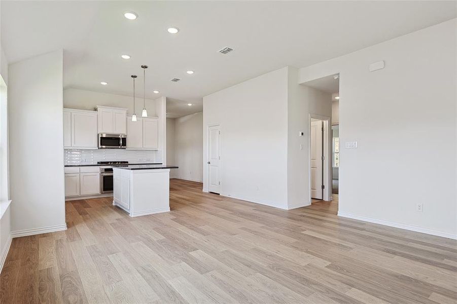 Kitchen with appliances with stainless steel finishes, white cabinetry, and light hardwood / wood-style floors