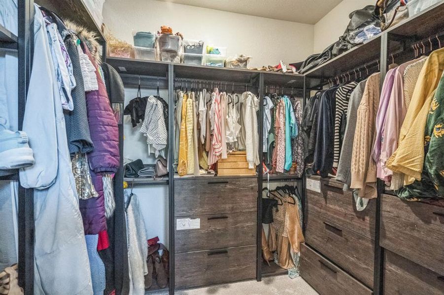 Primary closet with custom closet organizers.