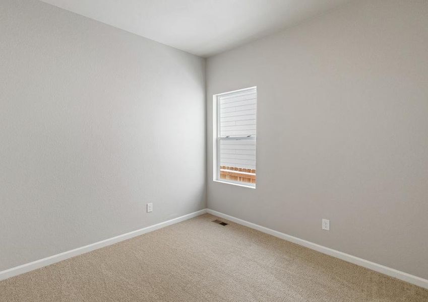 Secondary bedroom with a window, recessed lighting and tan carpet.