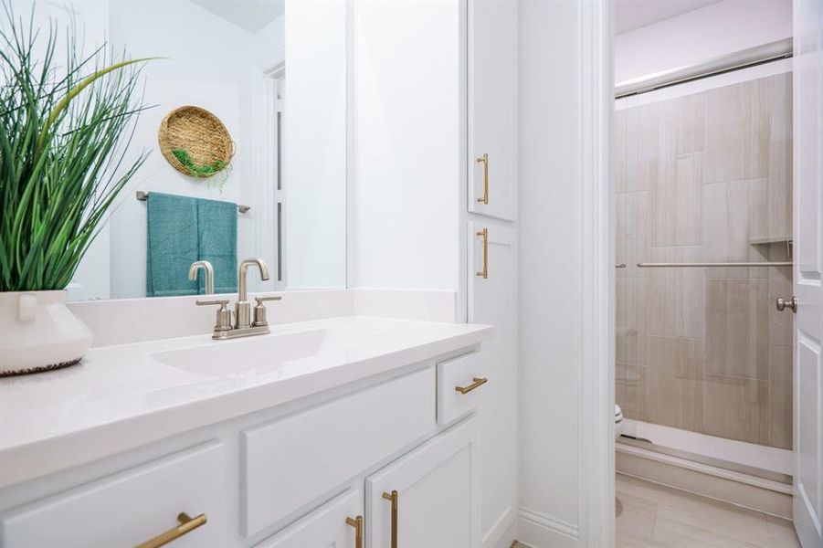 Bathroom featuring a tile shower and vanity