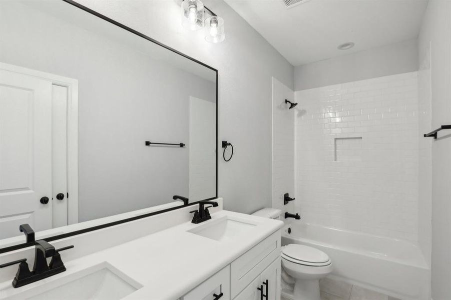 Full bathroom featuring toilet, shower / bathing tub combination, tile patterned flooring, and dual bowl vanity