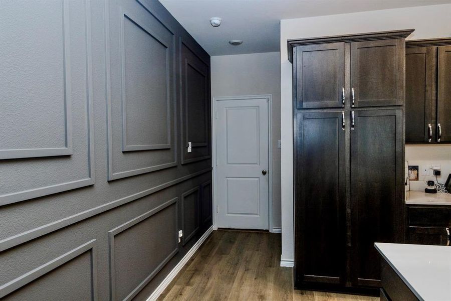 Kitchen with wood-type flooring and dark brown cabinets