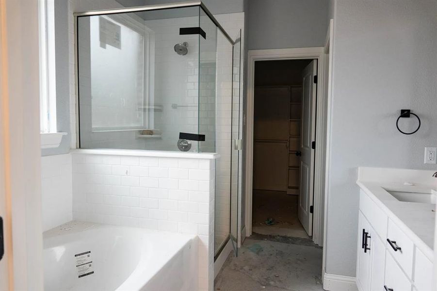 Bathroom featuring vanity and shower with separate bathtub