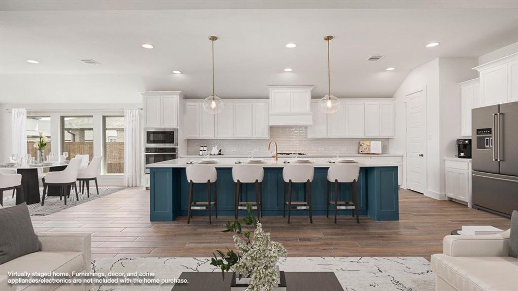 Kitchen with appliances with stainless steel finishes, pendant lighting, hardwood / wood-style floors, and tasteful backsplash