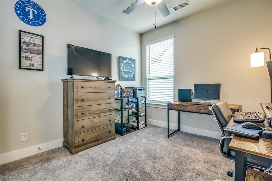 Carpeted office space featuring ceiling fan