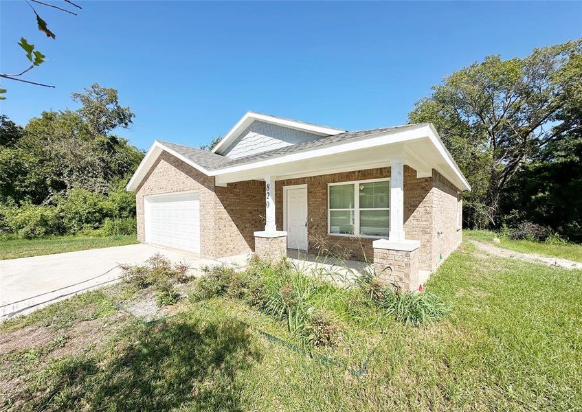 View of front of home featuring a front yard and a garage