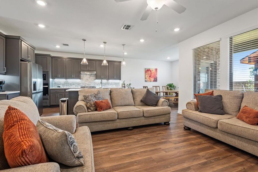 Living room with ceiling fan and dark hardwood / wood-style flooring