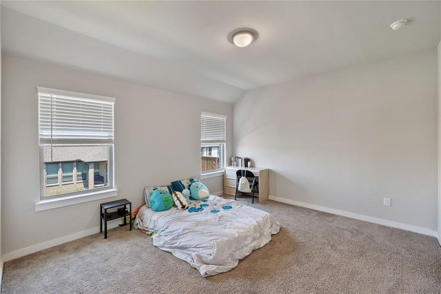 Carpeted bedroom with lofted ceiling