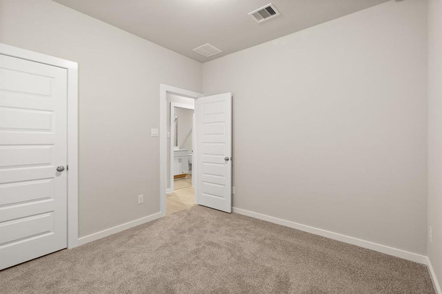 Stunning Secondary bedroom featuring plush carpet, neutral finishes and easy access to the Flex Space and bathroom.