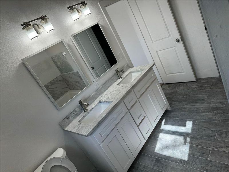 Master Bathroom with toilet, tile patterned floors, and dual bowl vanity