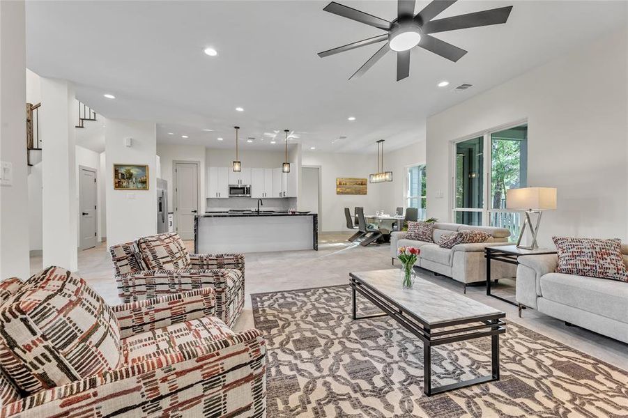 Upscale living room that is open into the kitchen and dinning area.  Lots of windows to bring in that natural light.