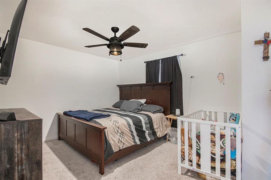 Bedroom with ceiling fan and light carpet