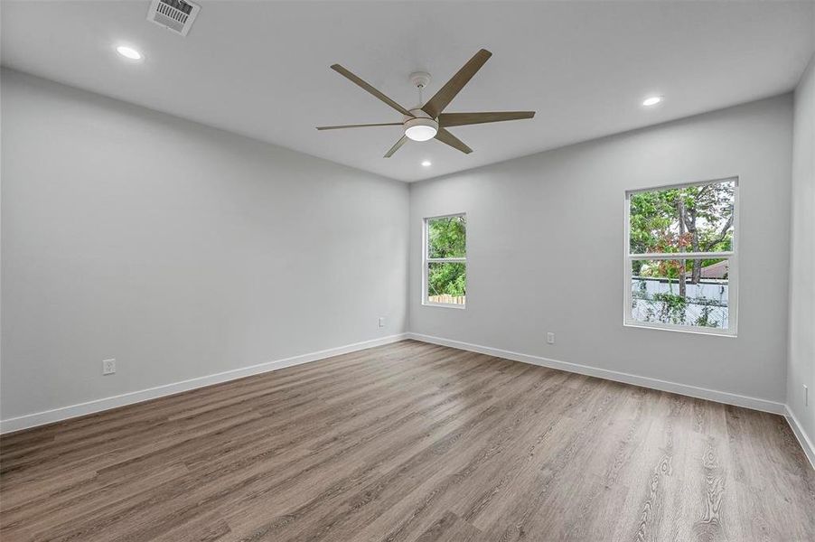 Unfurnished room with a healthy amount of sunlight, ceiling fan, and hardwood / wood-style flooring