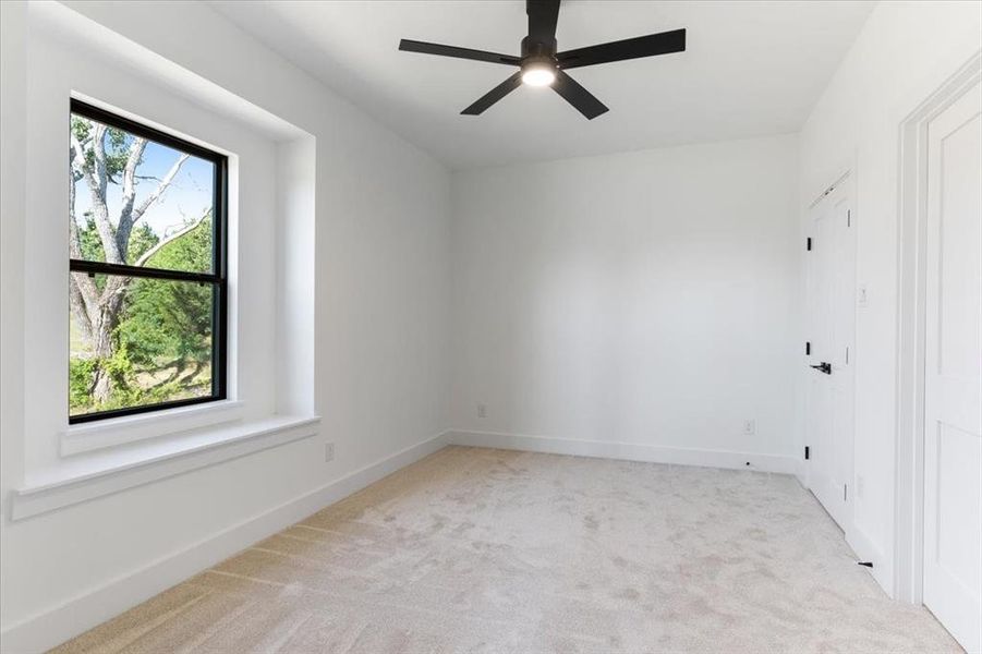 Carpeted spare room with ceiling fan