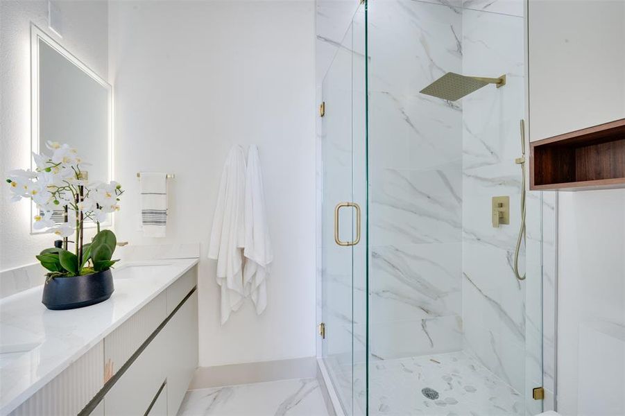 Bathroom featuring a shower with door and vanity