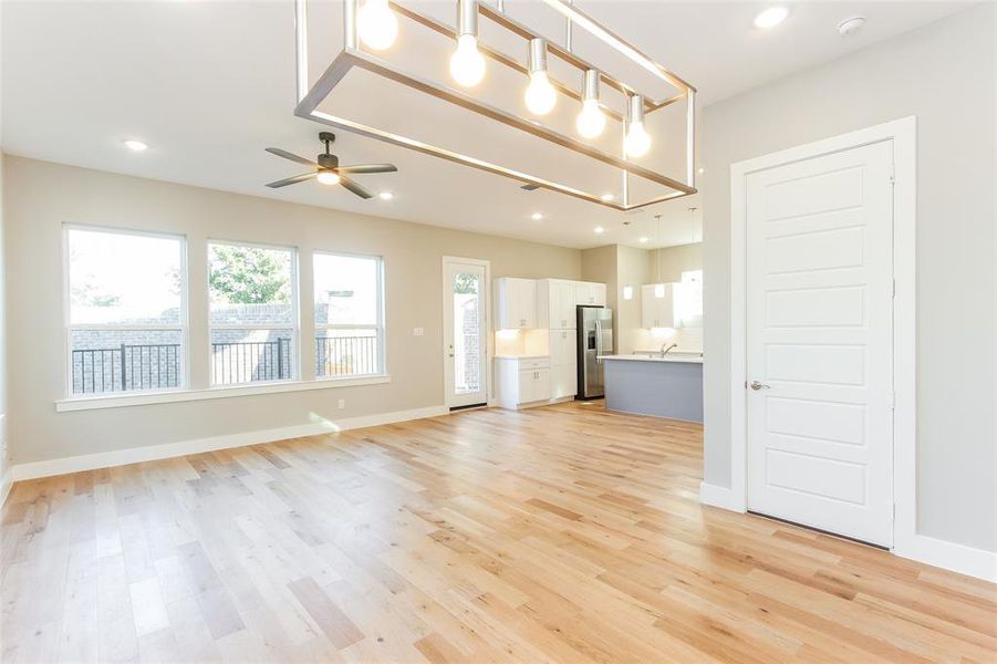 Unfurnished living room with ceiling fan and light hardwood / wood-style flooring