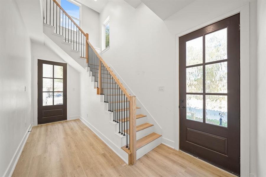 Grand entryway featuring high ceilings, LVP floors, and a spectacular stair case.