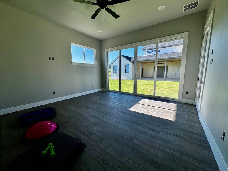 Empty room featuring ceiling fan and dark wood-type flooring