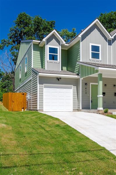 View of front of house featuring a garage and a front lawn