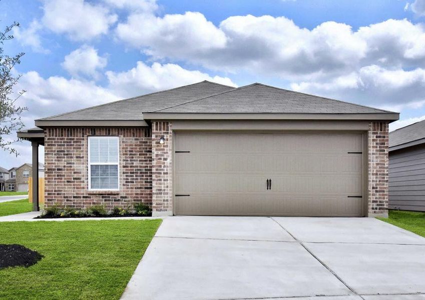 Medina finished home street view with brick siding, two car carriage style garage door, and landscape front yard