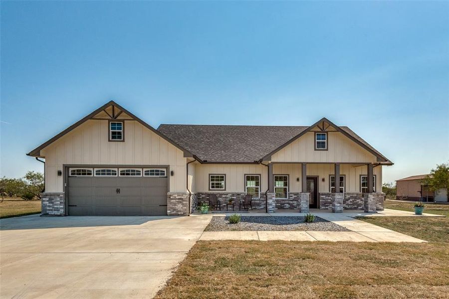 Craftsman-style house with a garage, a front lawn, and covered porch