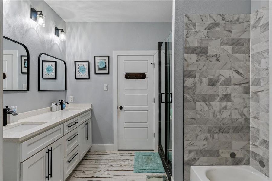 Bathroom featuring vanity, hardwood, and separate shower and tub