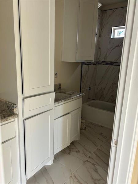 Hall full bath with real wood white cabinets and granite.