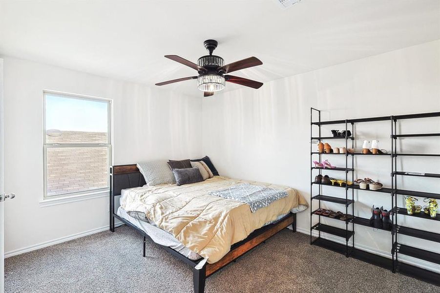 Carpeted bedroom featuring ceiling fan